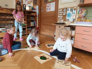 Dzieci układają puzzle montessori