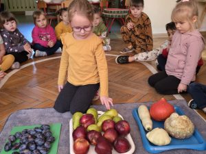 Dziewczynka przygląda się owocom wyłożonym na tacy