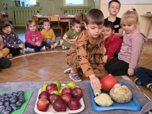 Chłopiec dotyka warzywa wyłożone na tacy