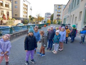 Dzieci stojące w parach przed budynkiem przedszkola