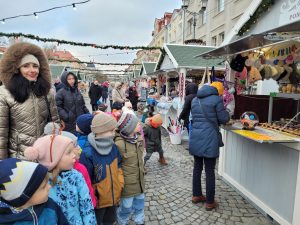 Dzieci i wychowawczyni przy stoisku z ozdobami świątecznymi