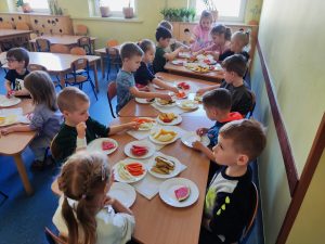 5. Dzieci tworzą kompozycje z owoców i warzyw na talerzu.