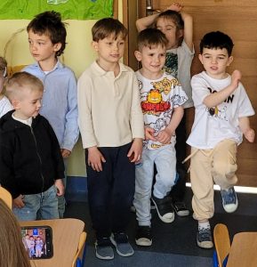 Chłopcy pokazują ruchem wiersz