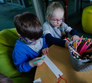 Lidka i Antoś ozdabiają zakładki do książki.