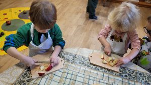 Dzieci kroją owoce.