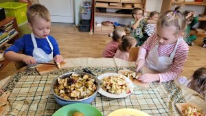 Dzieci kroją owoce na sałatkę owocową