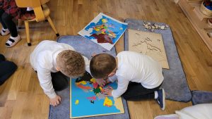 Chłopcy pracują z mapą Europy