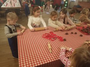 Dzieci wałkują ciasto na pierniczki