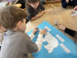 Dzieci wykonuja plakat o niedzwiedziu