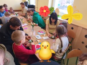 Dzieci z rodzicami wykonują ozdoby świąteczne