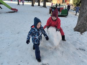 Jarek i Amadeusz cieszą się ze wspólnej zabawy na śniegu