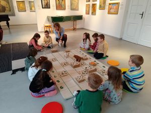 Lila pomaga Amadeuszowi rozpoznać zapach pracowni malarskiej.