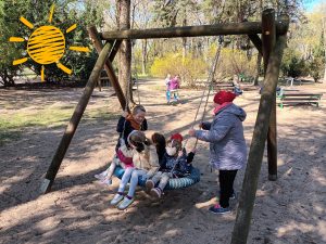 Staś pomaga Pani Iwonce huśtać koleżanki z grupy